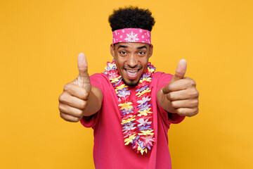 Young smiling happy fun cheerful man 20s he wear pink t-shirt hawaiian lei bandana near hotel pool...