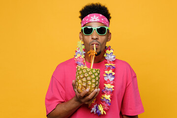Young fun stylish man 20s he wearing pink t-shirt sunglasses hawaiian lei near hotel pool drink...