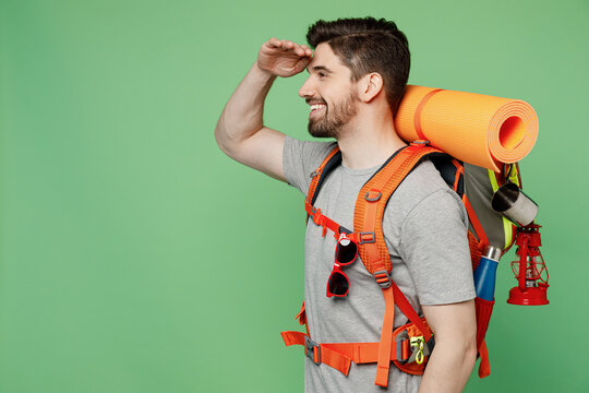 Young Happy Traveler White Man Carry Backpack Stuff Mat Look Far Away Distance Isolated On Plain Green Background Tourist Lead Active Lifestyle Walk On Spare Time Hiking Trek Rest Travel Trip Concept