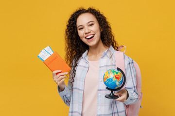 Traveler black teen girl student wear casual clothes hold passport tickets Earth world globe isolated on plain yellow background. Tourist travel high school study abroad getaway. Air flight concept.