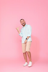 cheerful young happy man dance on pink background.