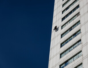 Industrial climber in helmet and uniform on height