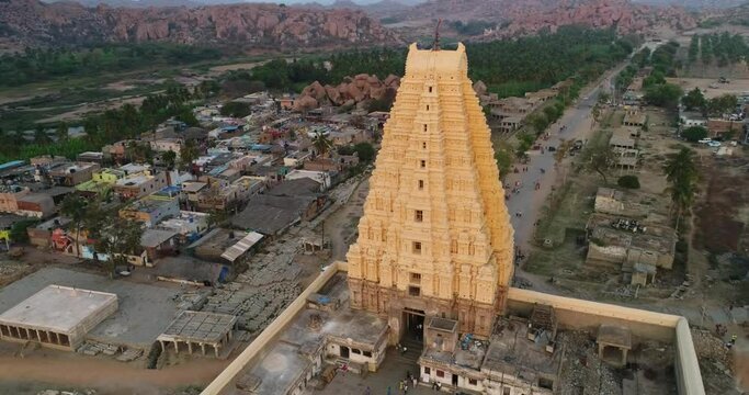 Aerial shot of hindu temple complex and village next to river at sunset