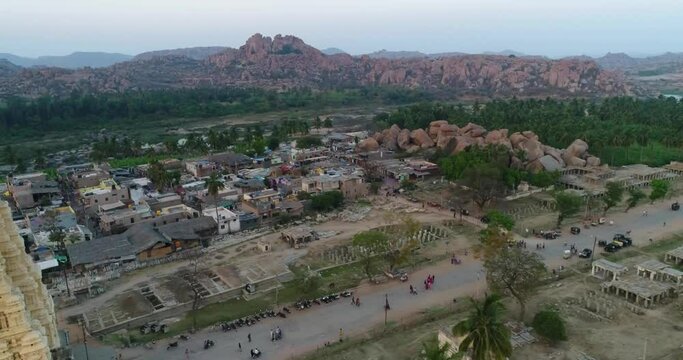 Aerial shot of hindu temple complex and village next to river at sunset
