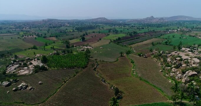 Aerial shot of countryside with fields and boulders hills between