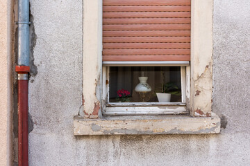 an old window with half-open roller shutters