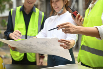 Engineer managers team wearing uniform and safety helmet inspecting industrial building construction site. Industry, Engineer, construction concept