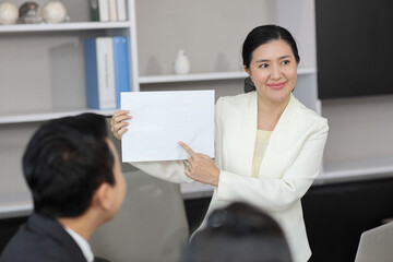 Collaborative process of professional businesspeople going over on new project, using paperwork and computer presentation with brainstorming ideas, coworker and work together at office meeting concept