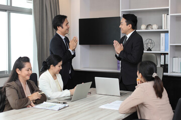 Image of success asian business people team posing pay respect sawasdee for greeting or say goodbye in modern office.