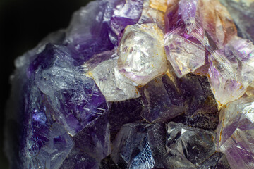 Ultra macro close up of a natural purple Amethyst quartz cluster isolated on black background 