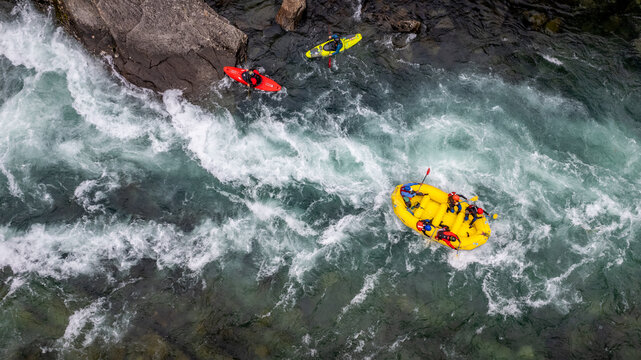 Group of friends spending time on the river enjoying kayaking and rafting together
