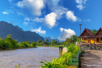 Fototapeta premium Vang Vieng Laos a beautiful city on the river with huge rising mountains and slow flowing river. 