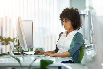 Thinking, vision and innovation with a young designer business woman working on a computer at her desk in the office. Ambitious young female with a mindset of growth, strategy and development