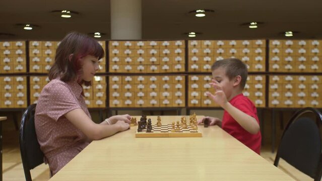 4K. Children play chess in the library