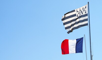 View of the French flag and Breton flag flying side by side in Brittany, France - obrazy, fototapety, plakaty