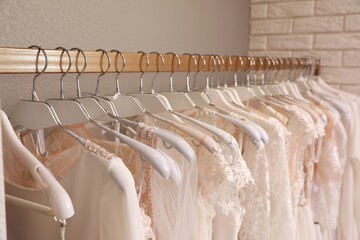Different wedding dresses on hangers in boutique