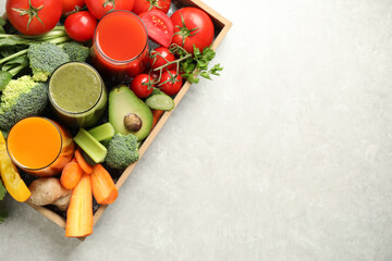Delicious vegetable juices and fresh ingredients on light grey table, top view. Space for text
