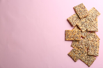 Delicious crackers on pink background, flat lay. Space for text