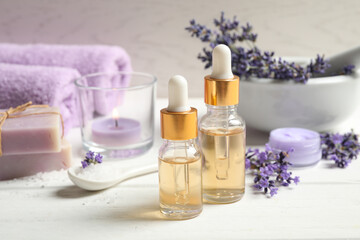 Plakat Composition with bottles of essential oil and lavender flowers on white wooden table
