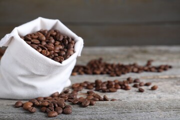 Bag of roasted coffee beans on wooden table, closeup. Space for text