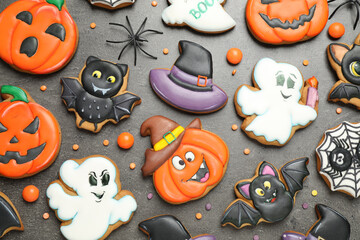 Tasty cookies and sweets for Halloween party on black table, flat lay