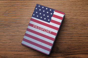 Passport in case with image of American flag on wooden table, top view