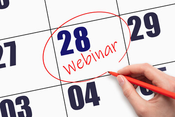 28th day of the month. Hand writing text WEBINAR and circling the calendar date. Webinar date on calendar or agenda. Day of the year concept.