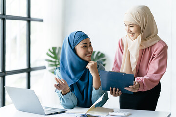 Portrait of muslim business woman wearing hijab, Business concept of signing the joint contract. Beautiful muslim business lady in hijab sitting together.