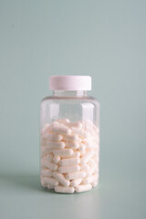 White pills and jar on the background. Side view.