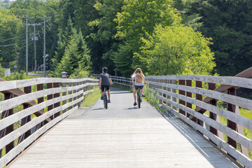 A pair riding bikes across rural bridge