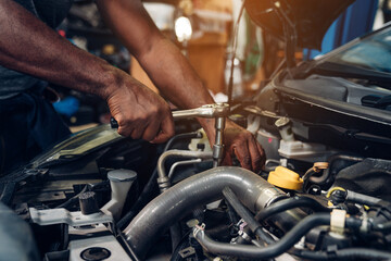 Closeup of auto mechanic are using the wrench to repair and maintenance auto engine is problems at car repair shop.