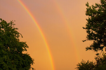 Sunset with two rainbows after a hurricane in the Kharkiv region of Ukraine in the summer of 2022