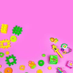 Flat lay plastic and wooden kids toys on pink background. Frame background with blank space, copy space, space for text