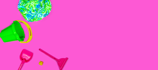 Flat lay plastic and wooden kids toys on pink background. Frame background with blank space, copy space, space for text