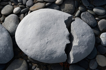 A white boulder has a huge crack in it, it has split in two