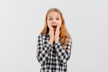 Amused teen girl hears wonderful news, raising hands joyfully, stare camera astonished, gasping open mouth wide in surprise, reacting amazed on promo, standing white background