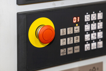 Red emergency stop button on the control panel, close-up. Machine control panel. Selected focus