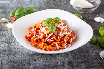 Orecchiette with fresh tomato sauce, basil and grated Italian ricotta. Typical dish of Italian...