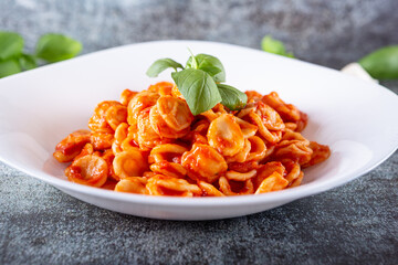Orecchiette with fresh tomato sauce and basil. Typical dish of Italian Cuisine. Vegetarian food,...