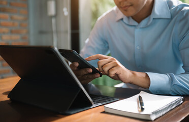 Send a message to a colleague, a businessman, confident in matching a tablet and sitting in office.