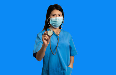 Portrait of a young woman doctor on a blue background.