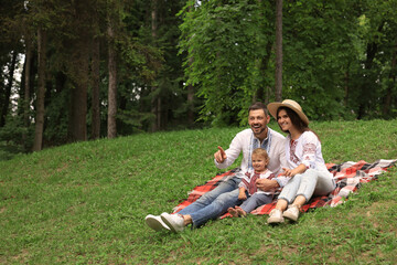 Happy family in Ukrainian national clothes on green grass outdoors