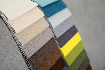 Catalog of colorful fabric samples on grey background, closeup