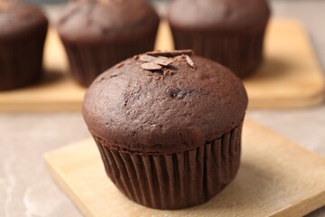 Delicious cupcake with chocolate crumbles on wooden board, closeup