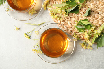 Flat lay composition with tasty tea and linden blossom on light grey table