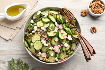 Delicious cucumber salad served on white wooden table, flat lay