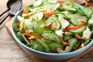 Delicious cucumber salad on wooden table, closeup