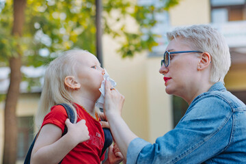 cute caucasian blonde little girl going to school. Mother having a conversation with child,