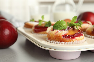 Delicious cupcakes with plums in baking pan, closeup