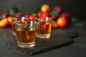 Delicious plum liquor on black table. Homemade strong alcoholic beverage